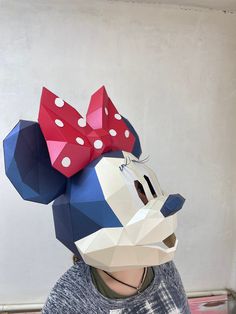 a person wearing a paper mask with a minnie mouse head on it's head