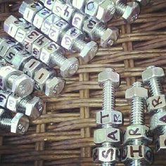 several nuts and bolts are arranged on a wicker basket with the letters abc and h