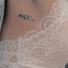 a close up of a woman's stomach with the word angel tattooed on it