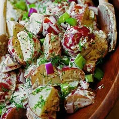 a wooden bowl filled with potato salad on top of a table