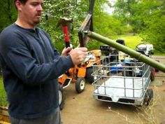 a man holding a hammer in his hand next to a small cart filled with tools