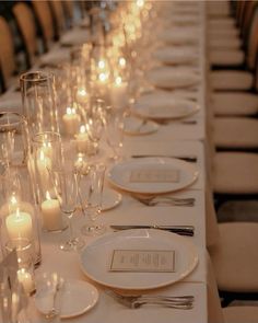 a long table is set with candles and place settings