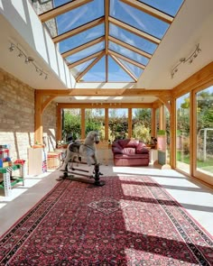 a living room with a large rug on the floor and a horse statue in the middle