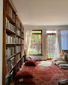 a room with bookshelves full of books and a large rug on the floor