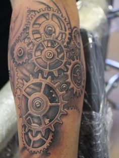 a man with a tattoo on his leg that has gears and cogs all over it