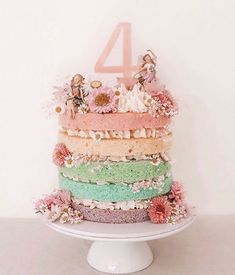 a multi layer cake sitting on top of a white plate next to a number four sign