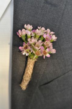 a boutonniere with pink flowers is tied to a suit