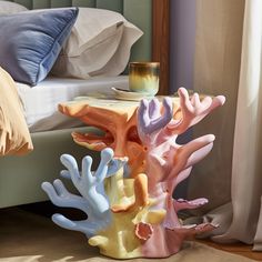 a bed room with a neatly made bed and colorful corals on the side table