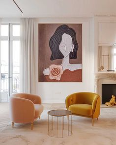 a living room filled with furniture and a painting hanging on the wall above a fire place