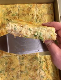 a person holding a knife over a casserole in a pan with broccoli and cheese