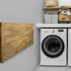 a washer and dryer sitting next to each other in a room with wooden shelves