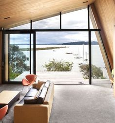 a living room with large windows overlooking the water