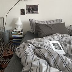 a bed with striped sheets and pillows in a bedroom