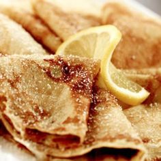 some pancakes with lemon slices and powdered sugar