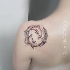 two dolphins in a circle tattoo on the left side of the right arm and shoulder