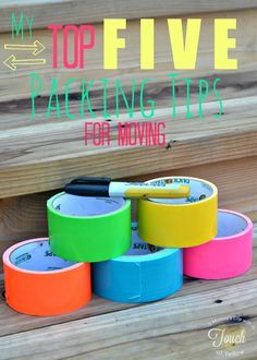 several different colored tape sitting next to each other on top of a wooden surface with the words my top five packing tips for moving