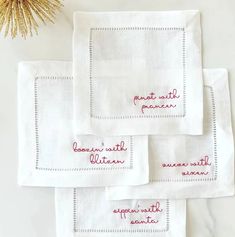 four embroidered napkins with words on them