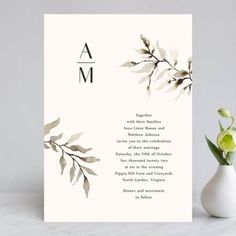 a white card with green leaves on it and the word am written in black ink