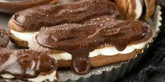 there are many cookies and pastries on the trays with chocolate frosting in them