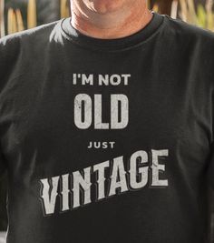 Discover the perfect gift that blends humor and style with our "I'm Not Old, Just Vintage" t-shirt! This tee is a delightful way to celebrate the timeless charm and wisdom of those special people in your life. Whether it's for a birthday, anniversary, retirement, or just because, this shirt makes a fantastic gift that will bring smiles and laughter. Product Features: High-Quality Material: Crafted from 100% soft, breathable cotton for ultimate comfort. Unique Design: A classic and funny message that reads "I'm Not Old, Just Vintage" printed in a stylish, retro font. Versatile Fit: Available in unisex sizes (S, M, L, XL, XXL) to fit all body types. Please refer to our size chart for the best fit. Vibrant Colors: Choose from a variety of colors to suit any taste - Black, White, Navy, Red, an Father's Day Long Sleeve Letter Print T-shirt, Father's Day Long Sleeve T-shirt With Letter Print, Long Sleeve T-shirt With Letter Print For Father's Day, Vintage Long Sleeve Slogan T-shirt, Funny Screen Print Tops For Father's Day, Funny Screen Print Top For Father's Day, Funny Father's Day Tops With Screen Print, Funny Graphic Print Tops As Gift, Vintage Long Sleeve T-shirt With Text Print