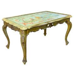 an antique table with floral designs painted on the top and bottom, sitting against a white background