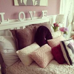 a white bed topped with lots of pillows