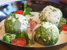 three balls of broccoli covered in white sauce and garnished with tomatoes