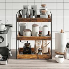 three tiered shelf with coffee cups and mugs on it in front of a white tiled wall