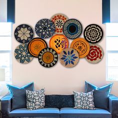 a living room filled with furniture and lots of plates hanging on the wall above it