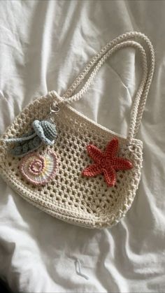 a crocheted purse with two starfishs on the front and one fish on the back