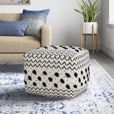 a living room with a couch, chair and ottoman in the middle of it on a blue rug