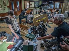 several people in a room with cameras and books