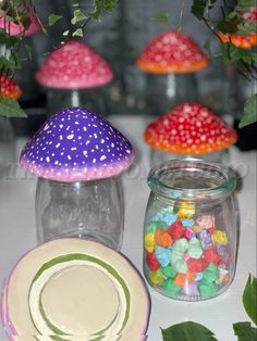 there are many different colored mushrooms in the glass jar and plates on the table next to each other