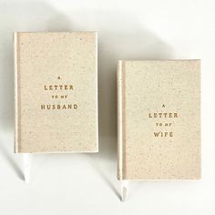 two small books with writing on them sitting next to each other in front of a white background