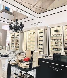 the inside of a store with many shelves and chandeliers on display in it