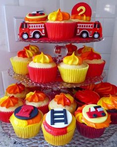 cupcakes with firetruck and cars on them sitting on a cake stand