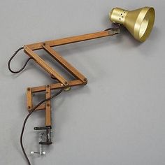 a wooden desk lamp with a light on it's side and a cord attached to the end