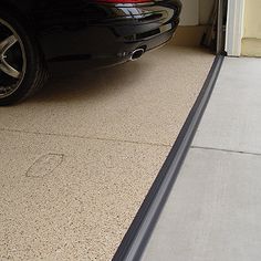 a black car parked in front of a garage door