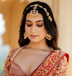 a woman wearing a red and gold bridal outfit