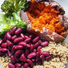 a white plate topped with beans and broccoli next to sweet potatoes on top of rice