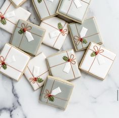 decorated cookies with bows and presents are on a marble countertop, ready to be eaten