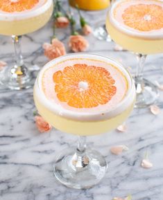 two glasses filled with orange juice and garnished with an orange slice on the rim