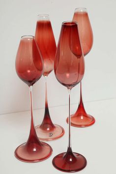 four red wine glasses sitting next to each other