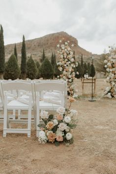 an outdoor ceremony with white chairs and flowers