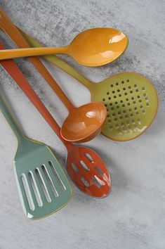 five different colored spoons are lined up on the table