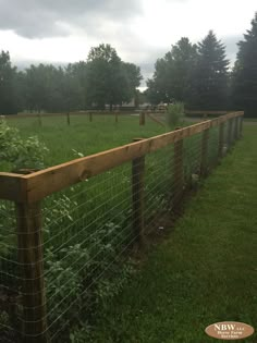 a wooden fence in the middle of a grassy field