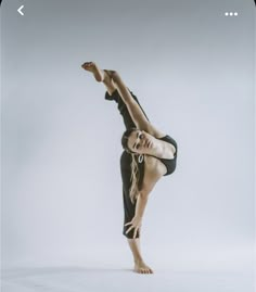 a woman is doing a handstand on one leg while standing in the air