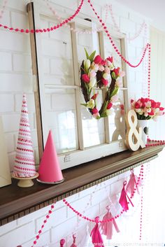 a mantel with pink and white decorations on it