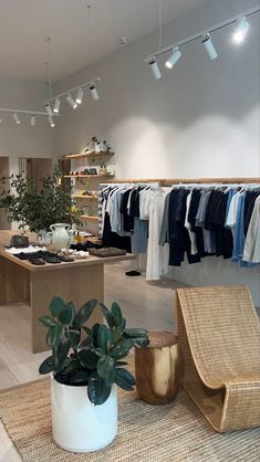 a clothing store with plants and clothes on racks