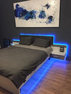 a large bed with blue lights on the headboard and foot board in a bedroom